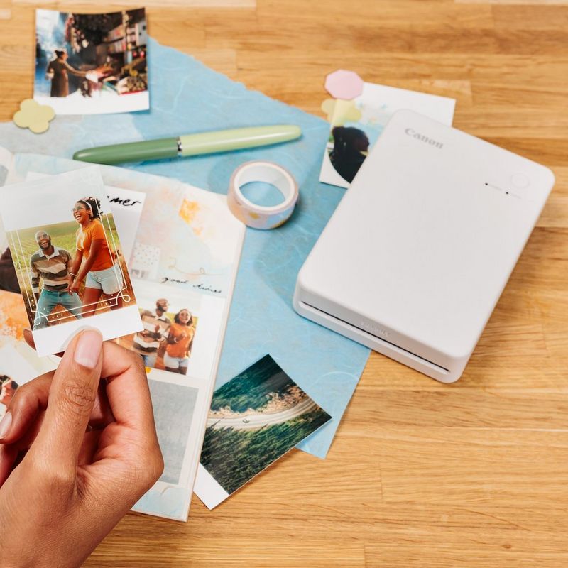 Canon SELPHY QX20 Portable Colour Photo Wireless Printer, Sand White Product showing printed photos