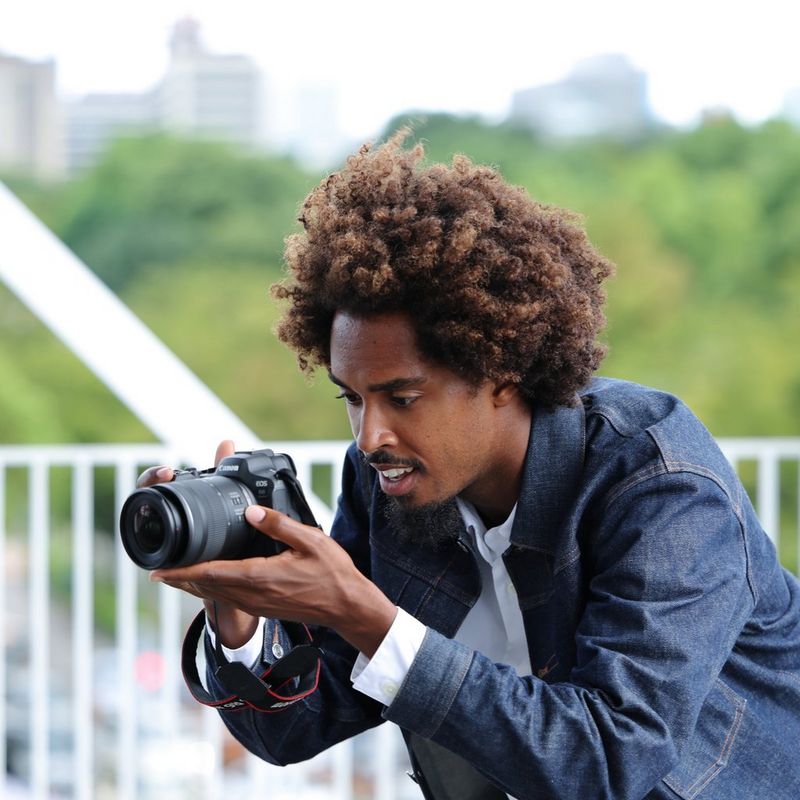 Canon RF 16-28mm F2.8 IS STM Lens Man clicking a photo in a city background
