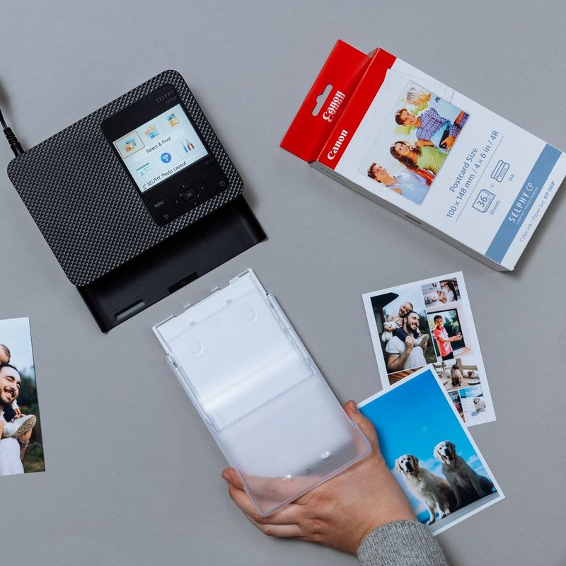 Sett med Canon KP-36IP fargeblekk + papir på 100 x 148 mm, 36 ark Person som skyver en skriverskuff