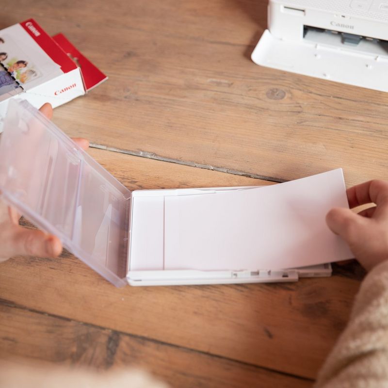 Sett med Canon KP-36IP fargeblekk + papir på 100 x 148 mm, 36 ark Person som fyller en skriverskuff