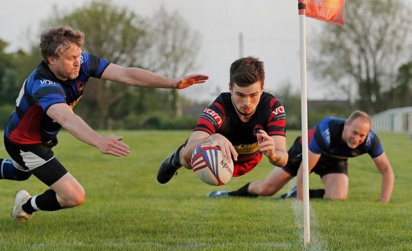 A rugby player is captured mid-air as he dives to score a winning try. Photo by Tom Jenkins. 