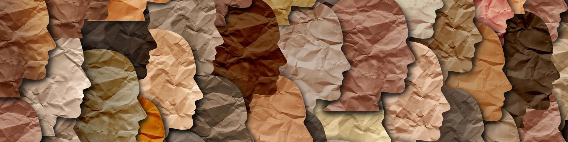 Featureless, slightly crumpled paper faces of all different skin tones, facing right and overlaid onto each other in a collage style