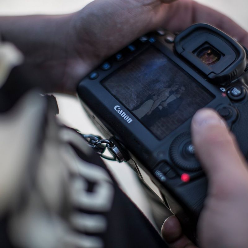 Photographer looking at pictures on a Canon camera display