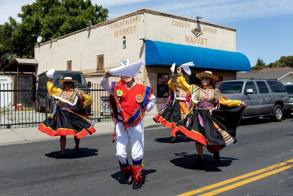 Four dancers in traditional Mexican dress perform in the middle of a street. Photo by Laura Morton.
