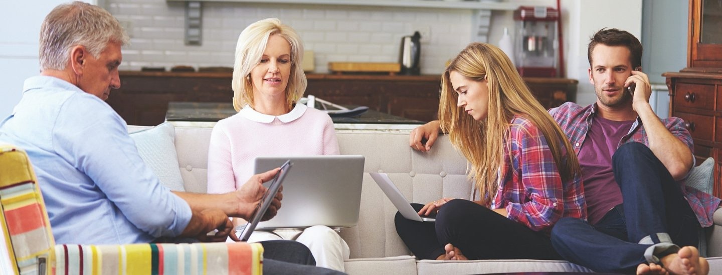 Family sat in living area on digital devices