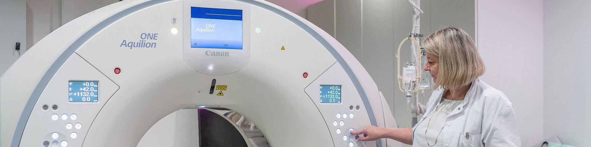 A female doctor pushes a button on Canon Aquilion ONE GENESIS CT Scanner