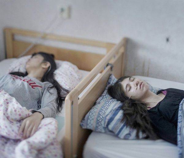 Djeneta (right) and Ibadeta are Roma refugees from Kosovo, now in Horndal, Sweden. They lie bedridden and unresponsive with uppgivenhetssyndrom (resignation syndrome).