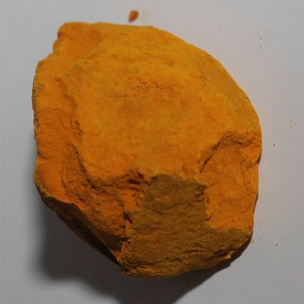A deep yellow/orange lump of ‘rock’, against a grey background.