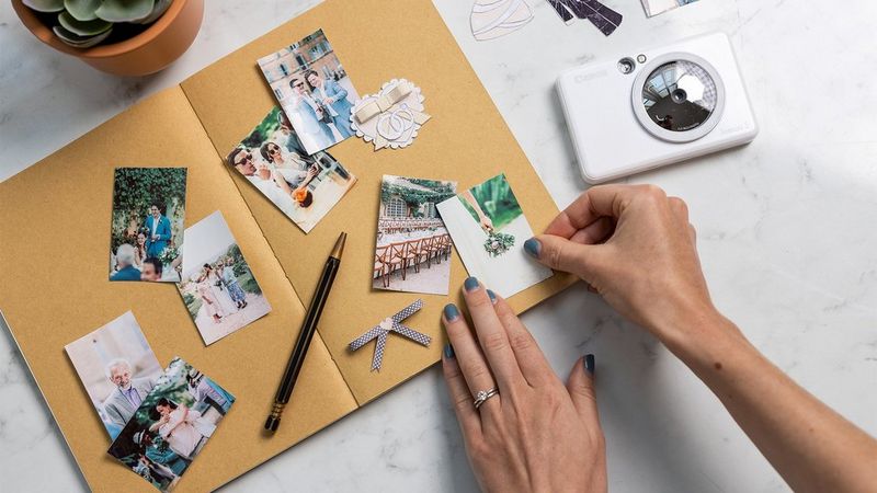 A scrap book being filled with images printed from a Zoemini S.