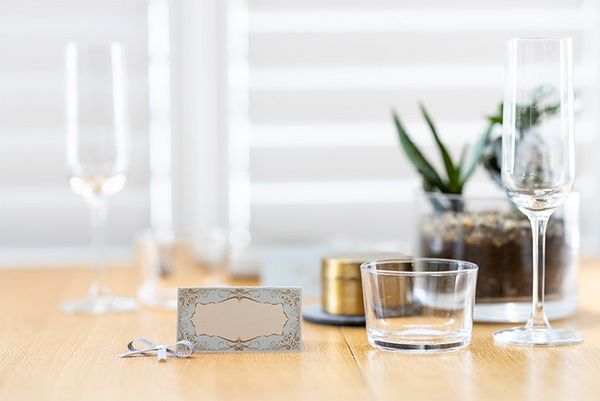 A tabletop with champagne flutes and home-printed place-cards.
