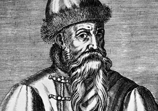 A black and white engraving of Johannes Gutenberg in which he is depicted with a long beard and what appears to be a high, fur-trimmed hat and matching high-necked jacket. 