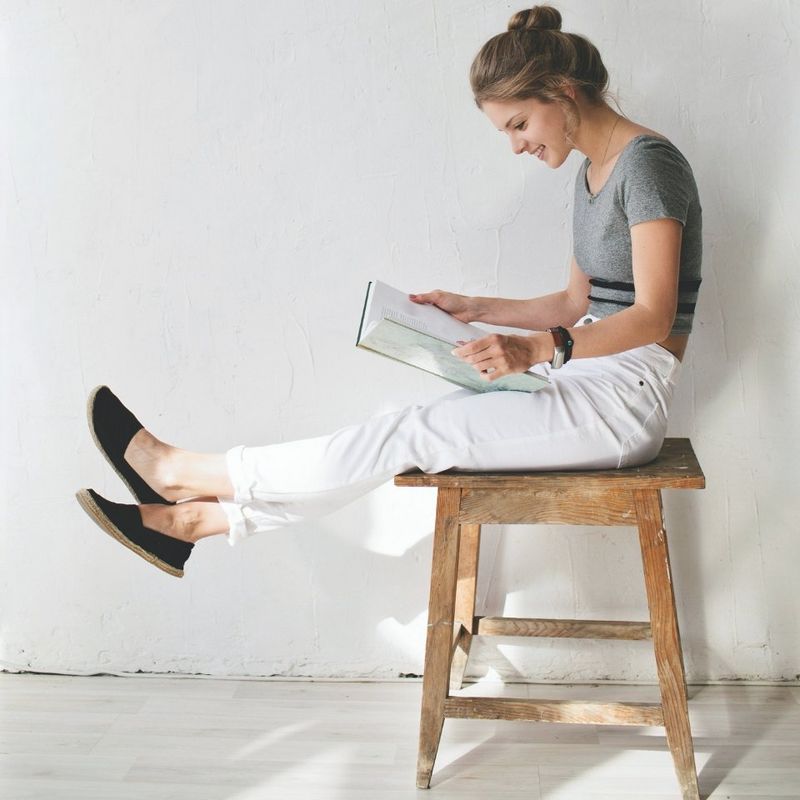 Girl sat on stool reading book