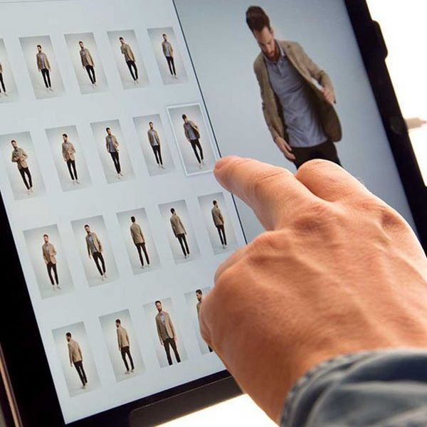 A man’s hand selects an image on an Apple iPad.