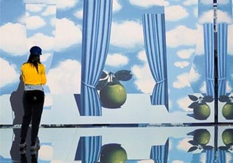 A gallery with mirrored walls and ceilings immerses visitors in projected images of Magritte’s paintings.