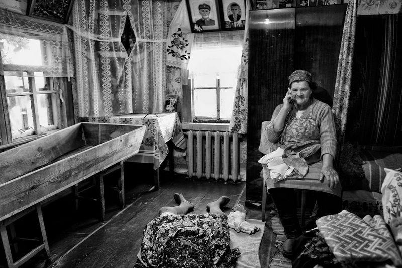 A woman on the phone in a small room, photographed by Maciek Nabradalik.