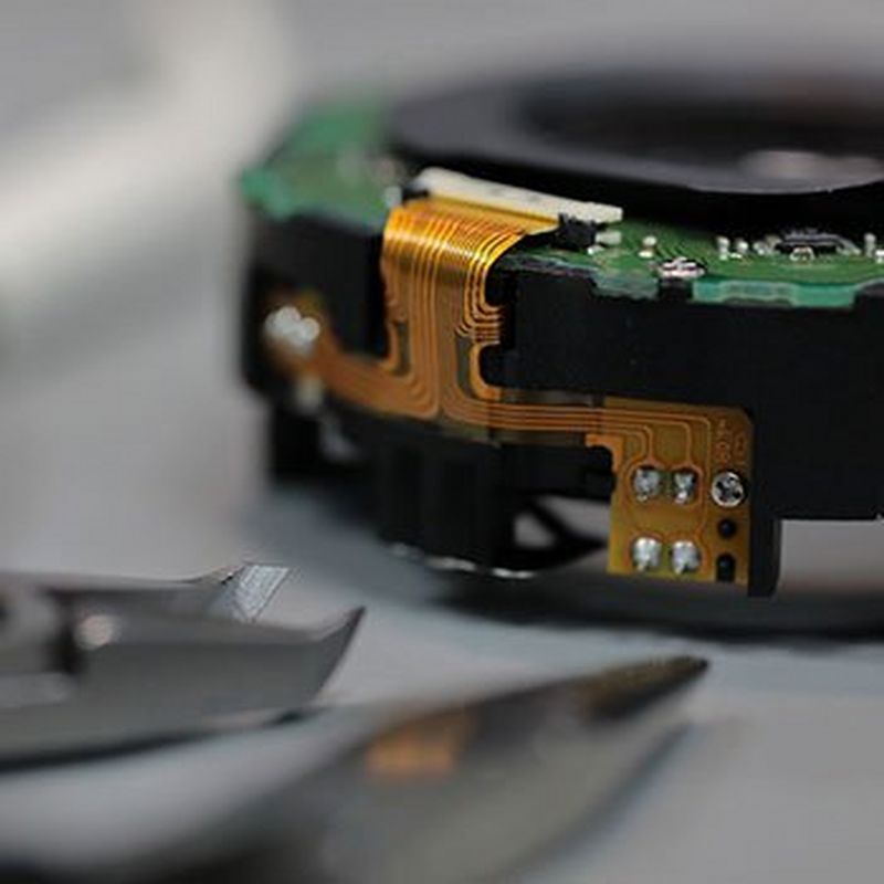 A Canon component with repair tools placed on a desk