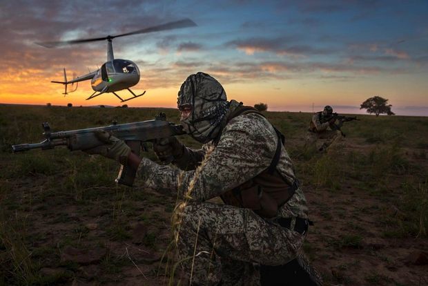 A two-man security team deploys by helicopter at sunset for anti-poaching duties on the worlds largest rhino breeding ranch at Buffalo Dream Ranch, Klerksdorp, South Africa.