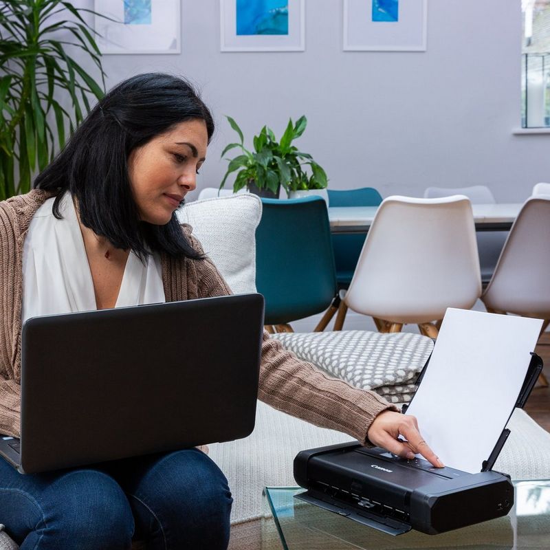 Canon PIXMA TR150 mobiler Tintenstrahldrucker Produkt Schrägansicht mit einer Person, die den Drucker bedient