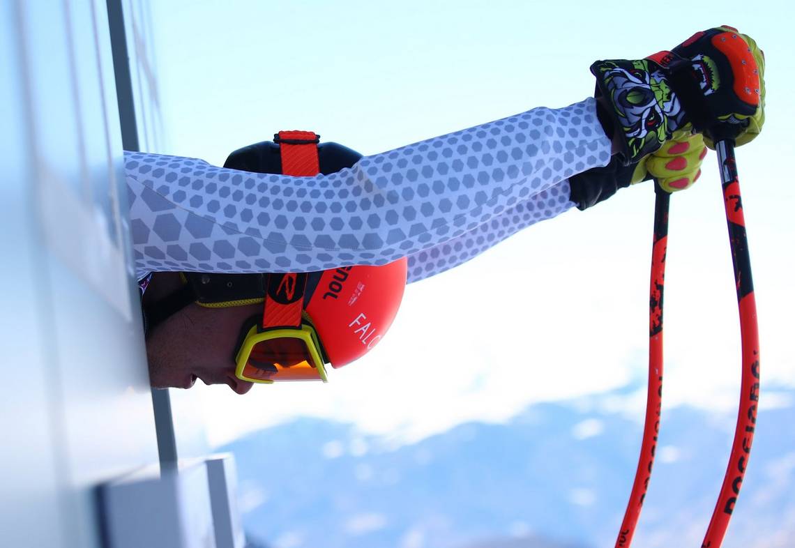 A close-up of a skier preparing to launch himself down a slope.