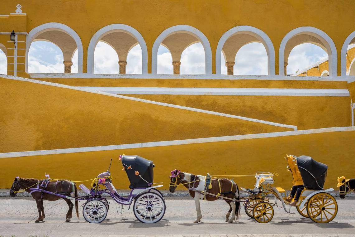 Horses and carriages awaiting passengers by the Convent in Izamal, Mexico.