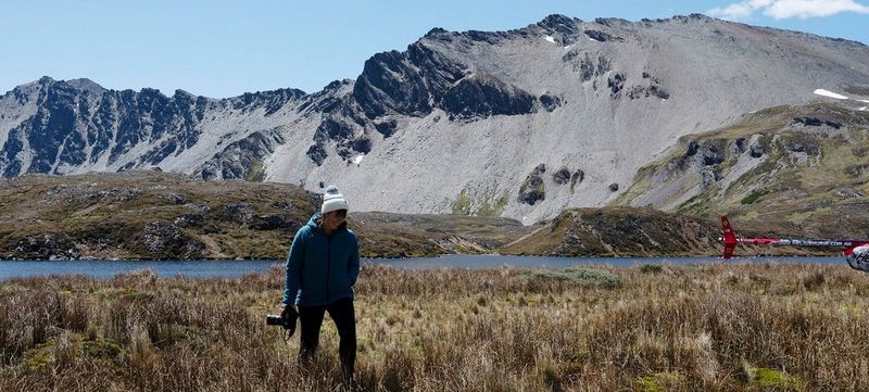 Lucia Griggi holding a Canon camera in the Andes Mountains in Patagonia, South America.