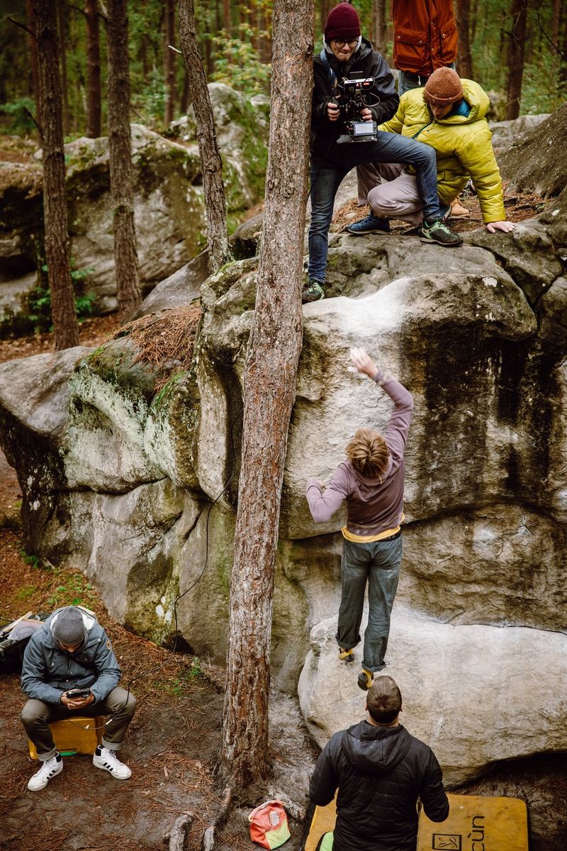Filmmaker Nicolai Deutsch stands on a boulder filming rock climbers from above with a Canon EOS C500 Mark II.