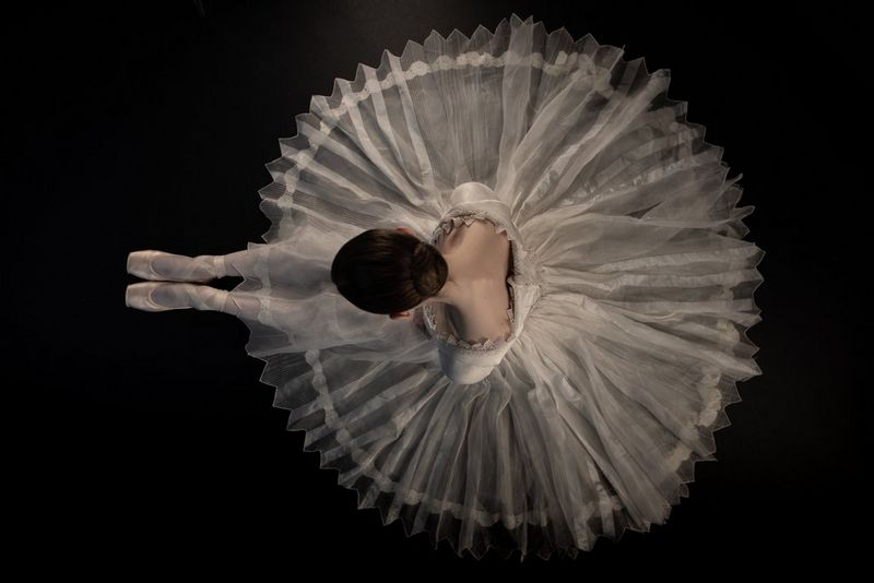 An overhead shot of a seated ballerina in a white tutu by Canon Ambassador Clive Booth.