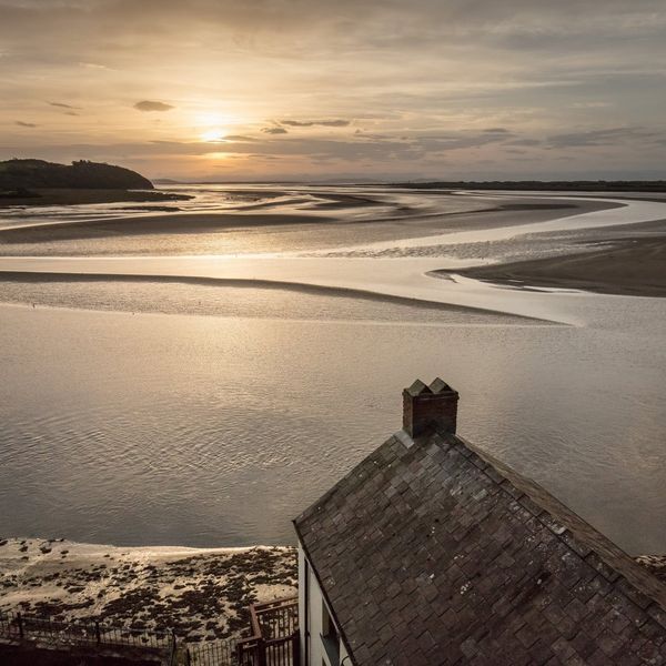 The sun sets in front of Dylan Thomas Boathouse in Laugharne, Dyfed, Wales.