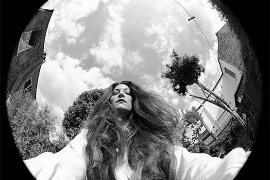 A black-and-white image shot with a fisheye lens of Canon Ambassador Wanda Martin looking down at the camera, her long hair falling around her shoulders.