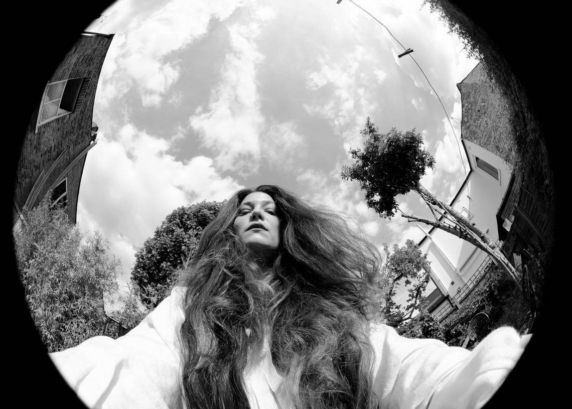 A black-and-white image shot with a fisheye lens of Canon Ambassador Wanda Martin looking down at the camera, her long hair falling around her shoulders.
