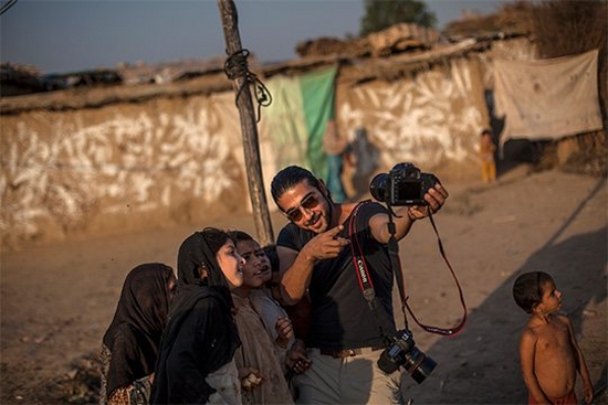 Canon Ambassador Muhammed Muheisen explaining how his camera works to a group of Afghan children.
