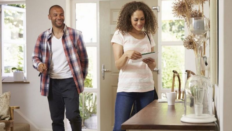 Couple looking at post as they come through door