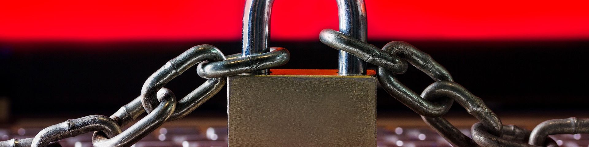 A padlock and chain on a red and black background.