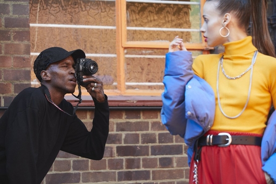 Photographer Ejiro Daf photographs a woman in bright clothing with a Canon ֽ_격-6 and a Canon RF 50mm F1.8 STM lens.