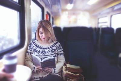 Girl reading book on train
