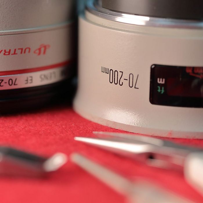 A Canon L lens with tools sitting on a repair table