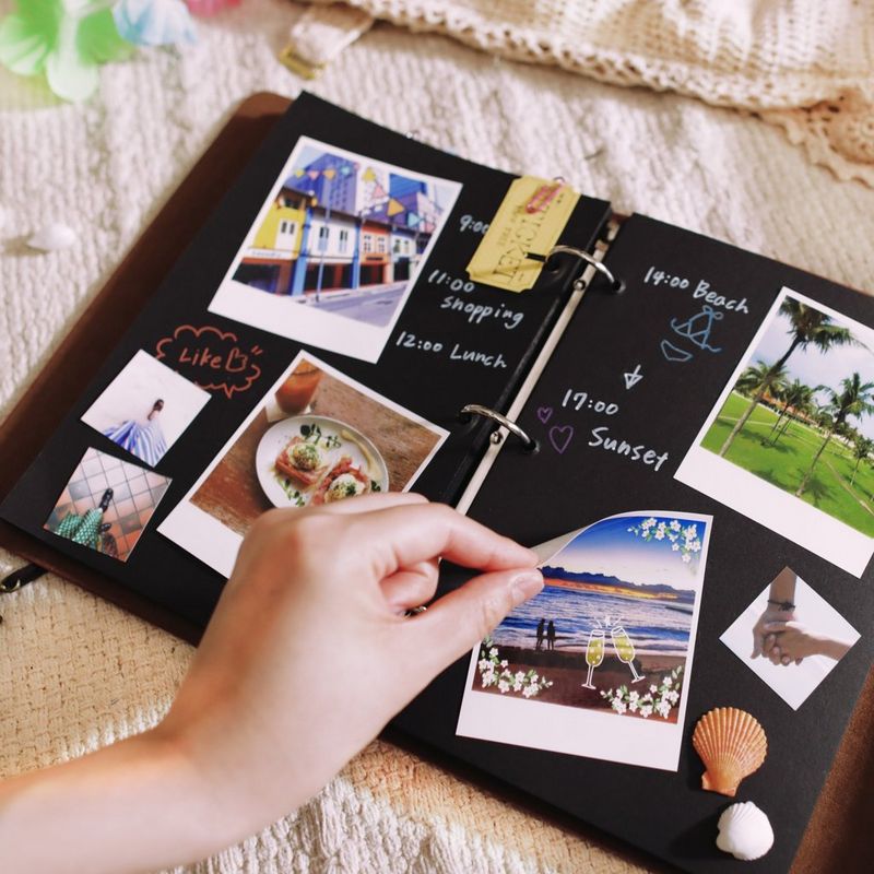 Canon SELPHY SQUARE QX10 Portable Colour Photo Wireless Printer, White Hand sticking photos on an album