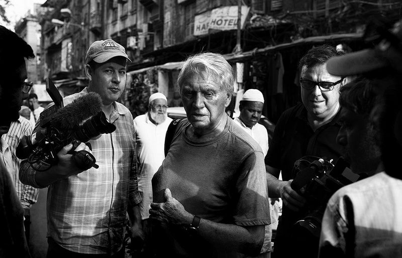 Sir Don McCullin works through the crowds with cinematographer Chris Clarke (left): “We had to be quick on our toes, because of the fast pace of where we were shooting,” says Chris. “These environments were either really cramped, or places that were quite open but crowded with thousands of people.” © Lance Miller 