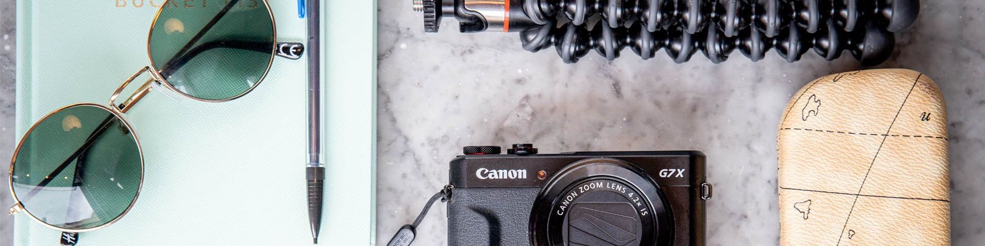The tools of a vlogger. Camera, notebook, pen, sunglasses and gorilla pod.