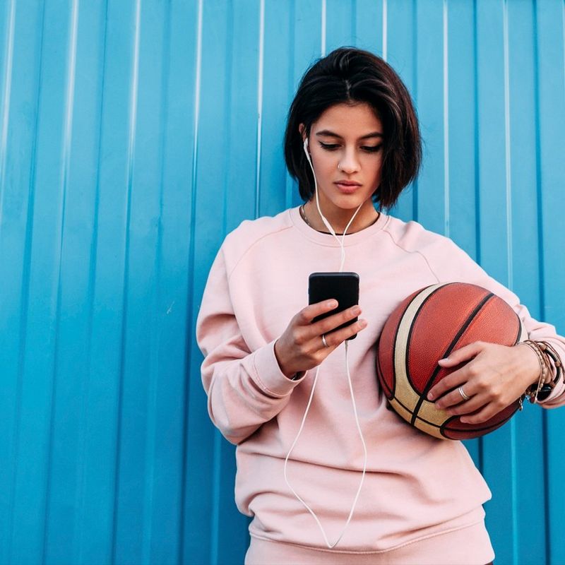 Woman with basketball in front of blue wall