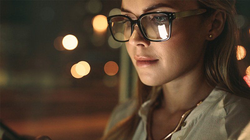 lunettes d'une femme regardant un écran