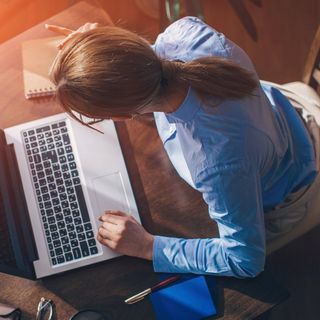 Picture of a woman sitting at a table working on her laptop
