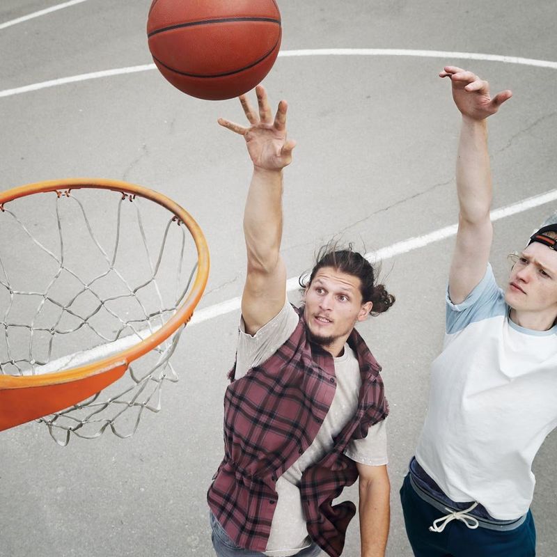 Two friends playing basketball in driveway