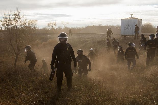 Riot police clear marchers from a secondary road outside a Dakota Access Pipeline (DAPL) worker camp using rubber bullets, pepper spray, Tasers and arrests.