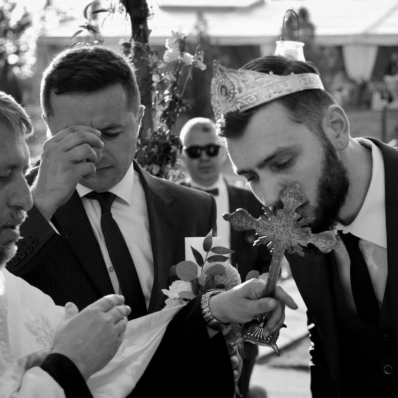 Scenes at Romanian wedding - Groom kissing Cross - taken with a EOS 5D Mark IV