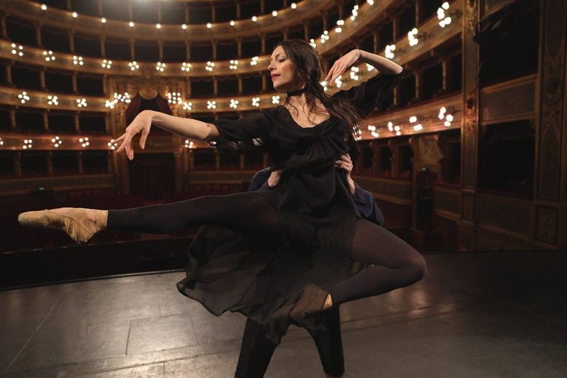 Cuplu care dansează balet în teatru.