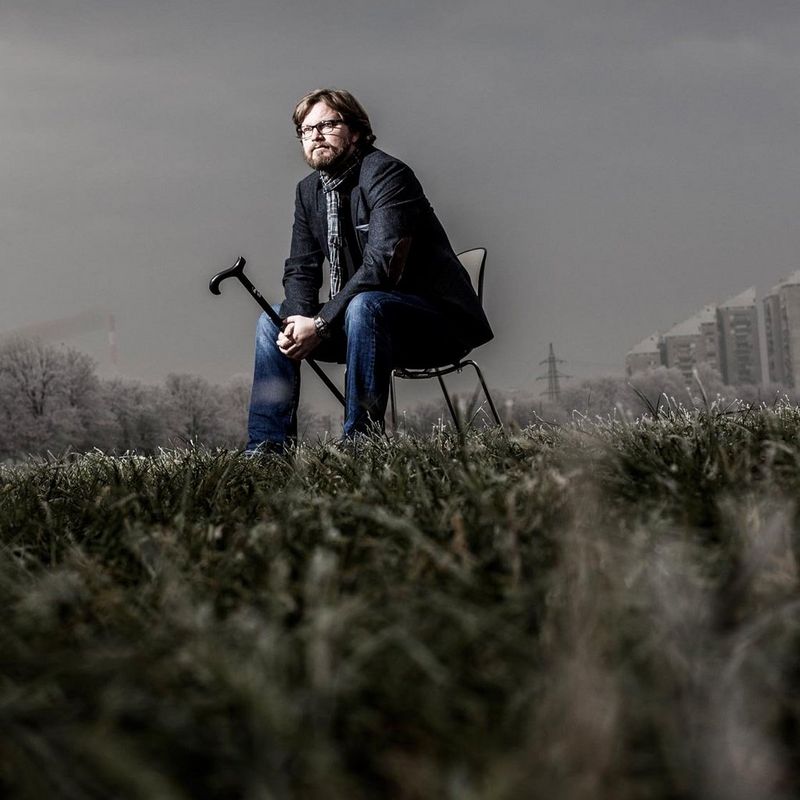 man sitting on chair in a field