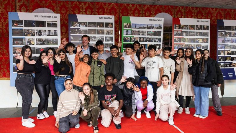 The young photographers of OKAN proudly pose for the camera at their exhibition.