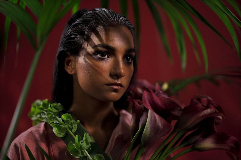 A model stands amid tropical flowers and plants. Photo by Guia Besana on a Canon EOS R.