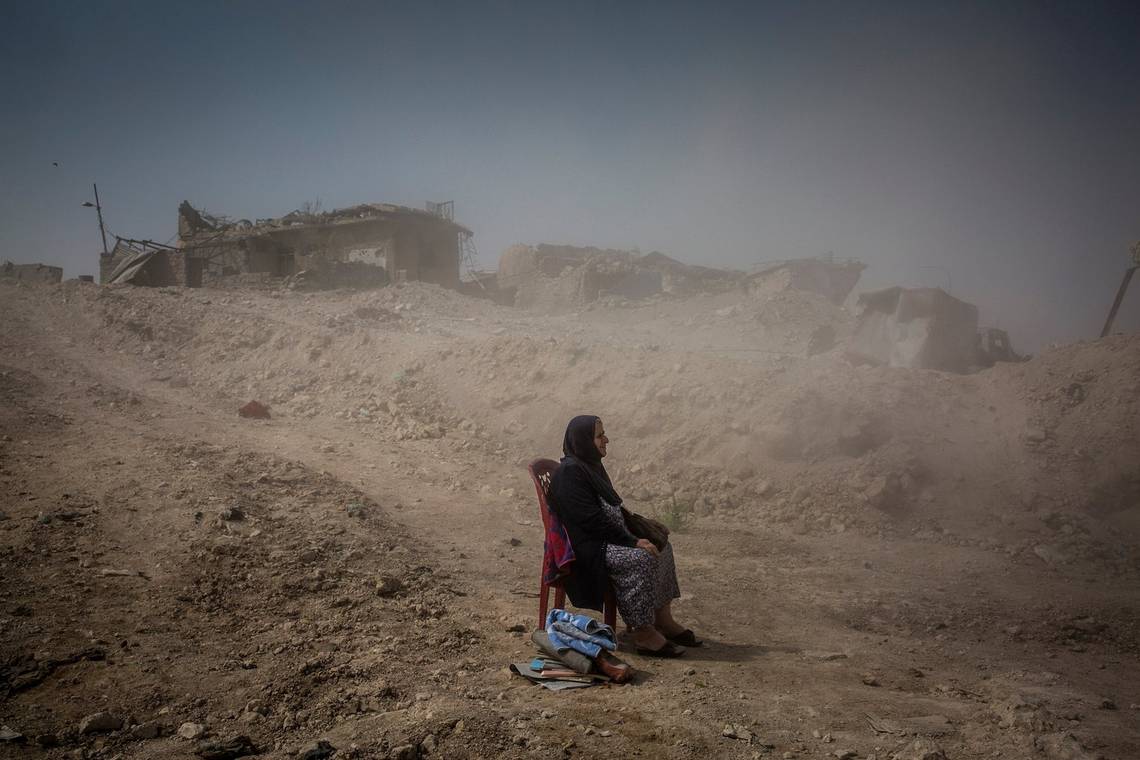 A woman sits in the rubble in the aftermath of the Battle of Mosul in 2017, by Canon Ambassador Ivor Prickett on a Canon EOS 5D Mark III.